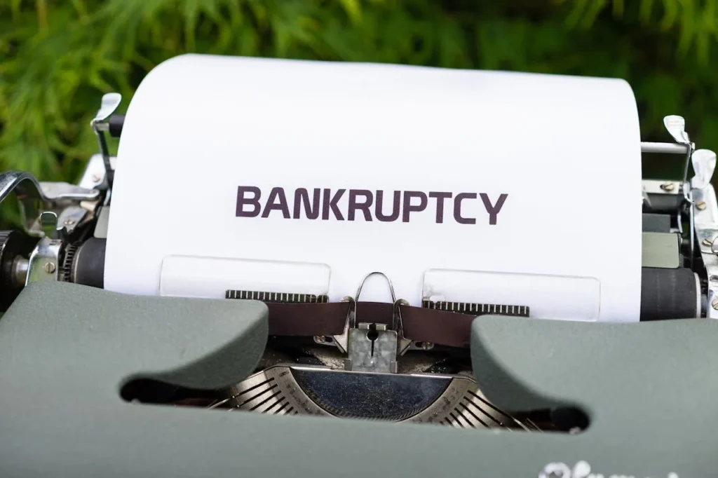 Close-up of a typewriter with a sheet of paper displaying the word 'BANKRUPTCY,' representing financial distress or legal bankruptcy proceedings.