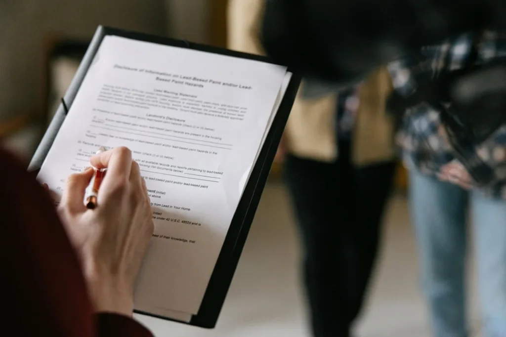 Person holding a clipboard with a legal property document, representing the review of real estate paperwork when buying property in Dubai as an expat.