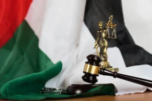 Gavel, scales of justice, and UAE flag displayed together, symbolizing labor law and legal rights related to employment and termination in Dubai.