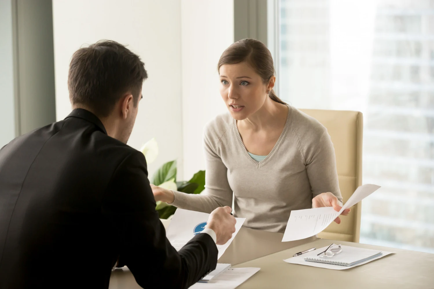 A woman discussing the contract with a lawyer in a black coat 